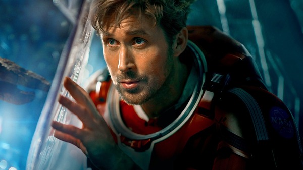 映画『プロジェクト・ヘイル・メアリー』宇宙船の窓の外を見つめる宇宙服姿のグレース(ライアン・ゴズリング)の場面写真
