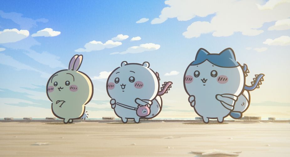 映画ちいかわ 人魚の島のひみつの一場面、浜辺に立つうさぎ・くりまんじゅうと島の生物
