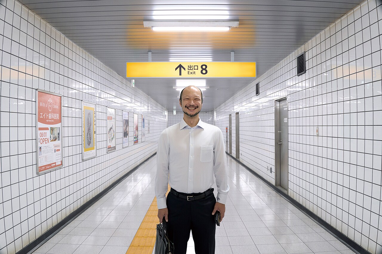 8番出口の看板が掲げられた地下通路に立つ映画の登場人物、原作ゲームの脱出ルールを再現した場面