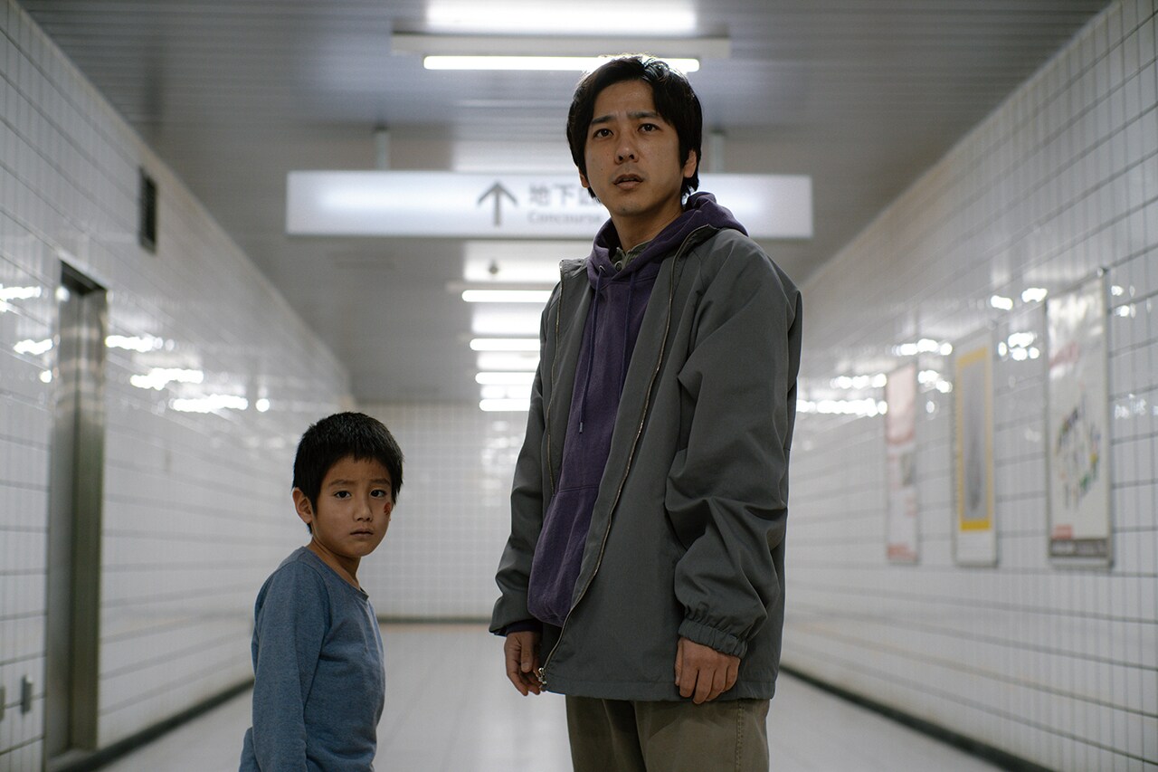 8番出口の地下通路で少年と共に立つ二宮和也演じる主人公の映画場面写真